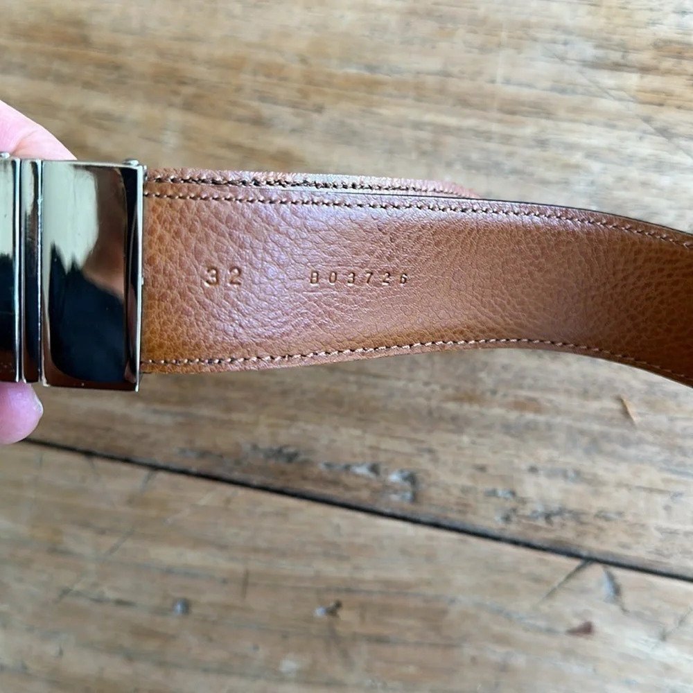 Reversible black and tan belt with silver buckle. Size 32.